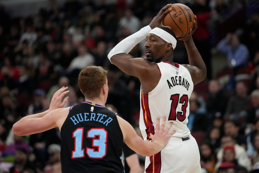 Chicago Bulls guard Kevin Huerter (13), left, guards Miami Heat center Bam Adebayo (13) during the first half of an NBA basketball game, Thursday, Jan. 29, 2026, in Chicago. (AP Photo/Erin Hooley)