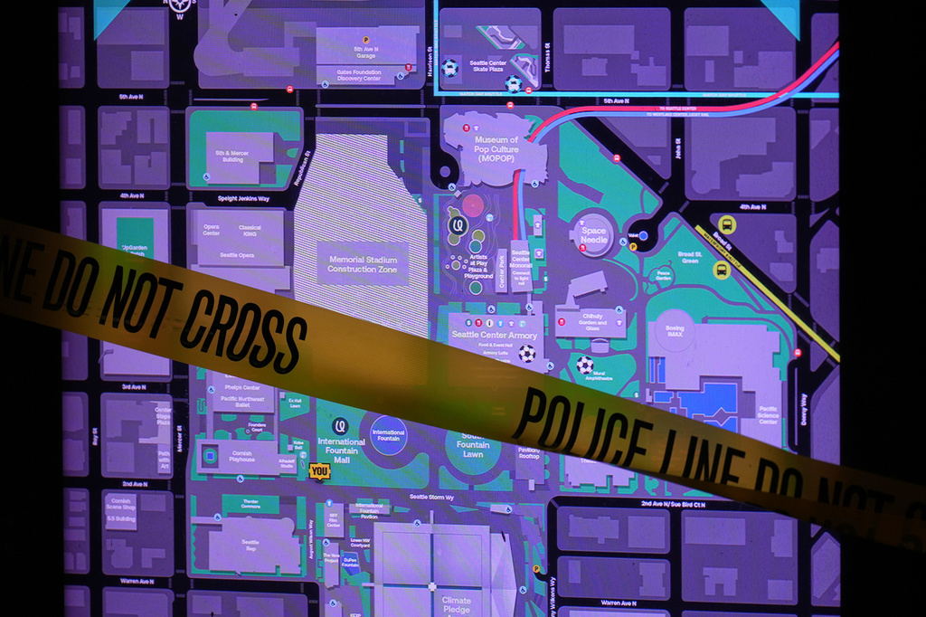 Police tape is seen across a map of Seattle Center after police responded to a shooting during the Bite of Seattle food festival Sunday, July 26, 2026, in Seattle. (AP Photo/Lindsey Wasson)