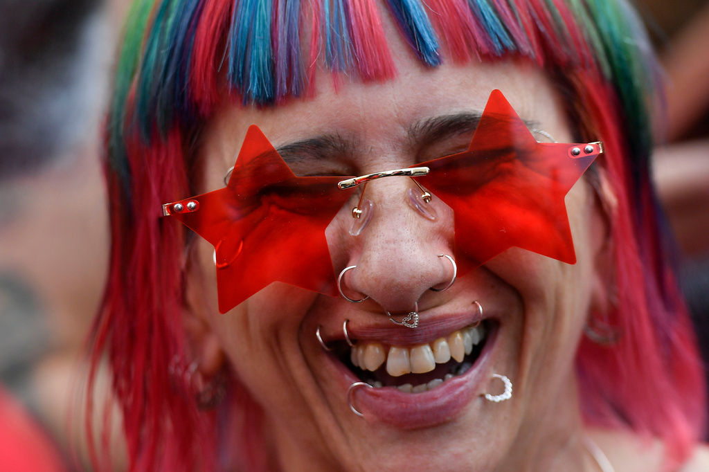 FILE - A woman wearing star-shaped glasses smiles during a campaign rally for former President Luiz Inacio Lula da Silva in Sao Paulo, Brazil, Oct. 29, 2022. (AP Photo/Matias Delacroix, File)