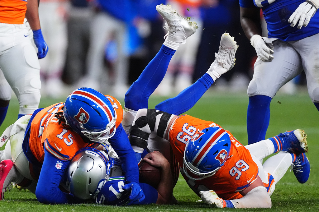 Denver Broncos defensive end Zach Allen (99) sacks Seattle Seahawks quarterback Sam Darnold with Broncos linebacker Nik Bonitto (15) during the second half of an NFL football game in Denver, Thursday, Oct. 15, 2026. (AP Photo/David Zalubowski)