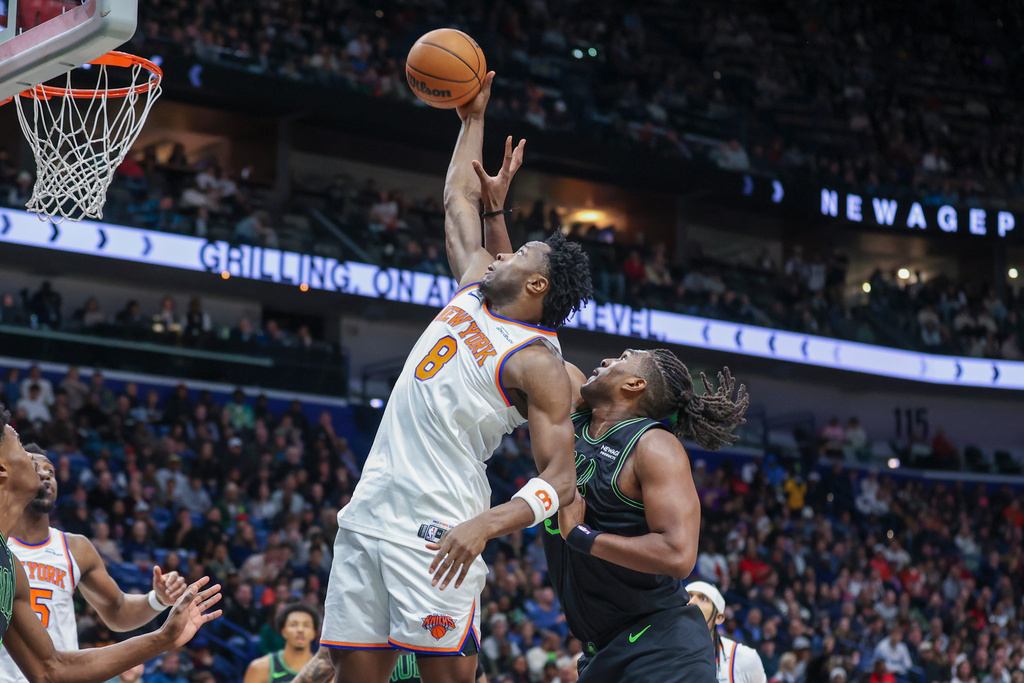 New York Knicks forward Og Anunoby (8) pulls down a defensive rebound against New Orleans Pelicans forward Kevon Looney, right, in the first half of an NBA basketball game in New Orleans, Monday, Dec. 29, 2025. (AP Photo/Peter Forest)