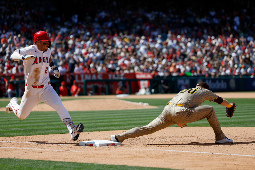 Los Angeles Angels' Mike Trout, left, runs to first base as San Diego Padres first baseman Gavin Sheets, right, catches the ball during the sixth inning of a baseball game Sunday, April 19, 2026, in Anaheim, Calif. (AP Photo/Caroline Brehman)