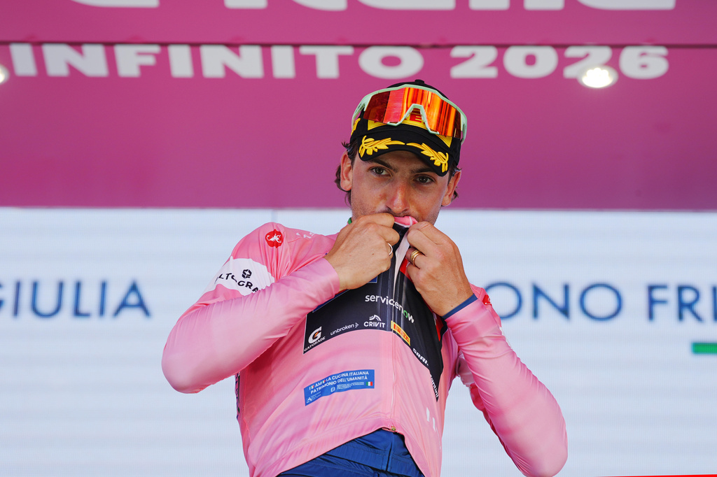 Italy's Giulio Ciccone kisses the pink jersey of the race overall leader on the podium after completing the 4th stage of the Giro d'Italia cycling race, from Catanzaro to Cosenza, Italy, Tuesday, May 12, 2026. (Gian Mattia d'Alberto/LaPresse via AP)