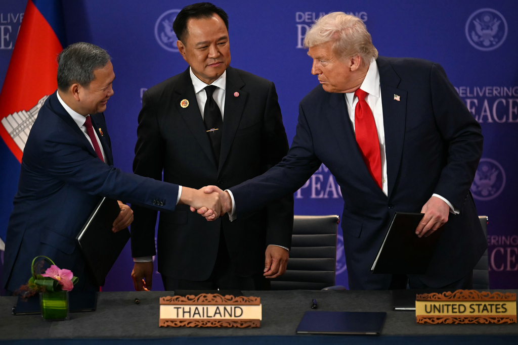 Thailand's Prime Minister Anutin Charnvirakul watches Cambodia's Prime Minister Hun Manet, left, and U.S. President Donald Trump shake hands on the sidelines of the 47th Association of Southeast Asian Nations (ASEAN) summit in Kuala Lumpur, Malaysia, Sunday, Oct. 26, 2025. (Mohd Rasfan/Pool Photo via AP)