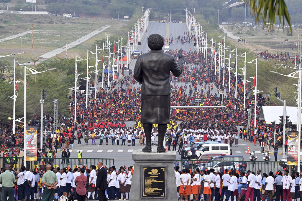 Papua New Guineans stand in front of a statue of Papua New Guinea's first Prime Minister Michael Somare during a flag raising ceremony at Parliament House in Port Moresby, Papua New Guinea, Tuesday, Sept. 16, 2025. (Mick Tsikas/AAP Image via AP)