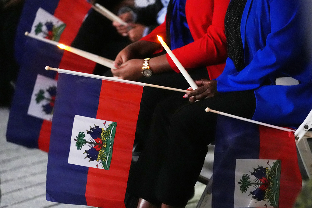 FILE - People hold Haitian flags and candles during a vigil at the Little Haiti Cultural Complex after a federal judge blocked the Trump administration from ending temporary immigration status, or TPS, for Haitians, Feb. 3, 2026, in North Miami. (AP Photo/Lynne Sladky, File)