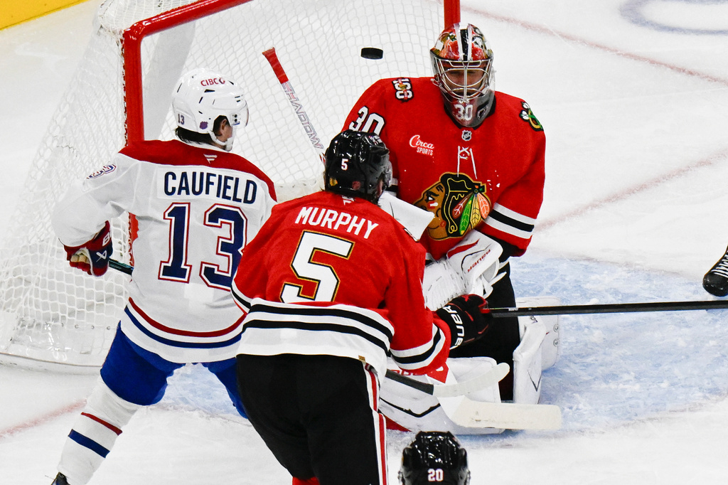 Montreal Canadiens right wing Cole Caufield (13) scores a goal against Chicago Blackhawks goaltender Spencer Knight (30) during the second period of an NHL hockey game Saturday, Oct. 11, 2025, in Chicago. (AP Photo/Matt Marton)