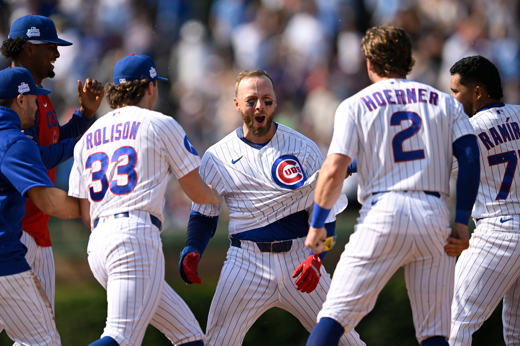Chicago Cubs' Michael Busch, center, celebrates with teammates after driving in the game-winning run with a single in the 10th inning of a baseball game to defeat the San Francisco Giants in Chicago, Saturday, June 6, 2026. (AP Photo/Paul Beaty)