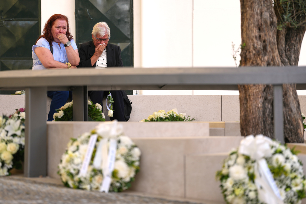 People react during the inauguration of a memorial to the 16 people killed in the derailment and crash of Lisbon's Glória funicular, an iconic streetcar, on the first anniversary of the accident, Thursday, Sept. 3, 2026. (AP Photo/Armando Franca)