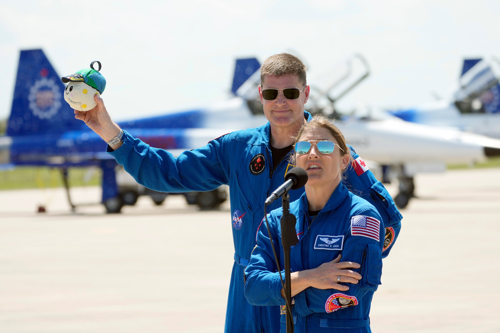 Artemis 2 crew members, Mission Specialist Christina Koch, front and Mission Specialist Jeremy Hansen, of Canada, speaks to the media after the crew's arrival at the Kennedy Space Center Friday, March 27, 2026, in Cape Canaveral, Fla. (AP Photo/Chris O'Meara)