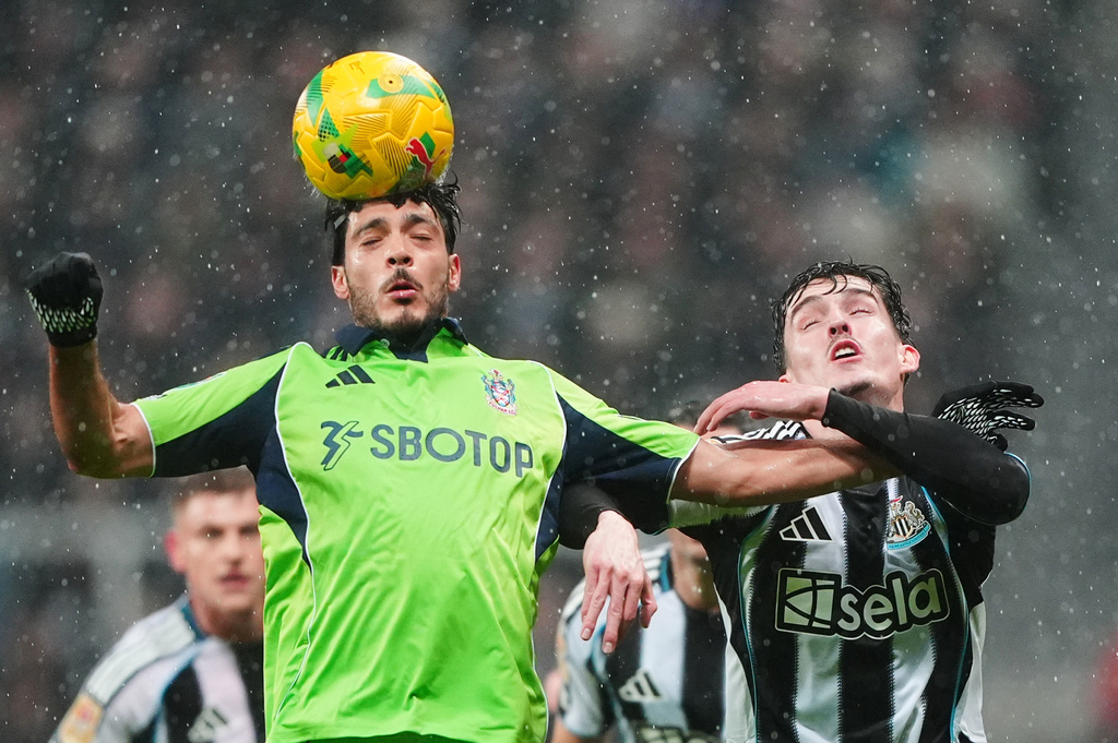 Fulham's Raul Jimenez, left, and Newcastle United's Tino Livramento battle for the ball during the English League Cup quarter final soccer match between Newcastle and Fulham in Newcastle upon Tyne, England, Wednesday, Dec. 17, 2025. (Owen Humphreys/PA via AP)