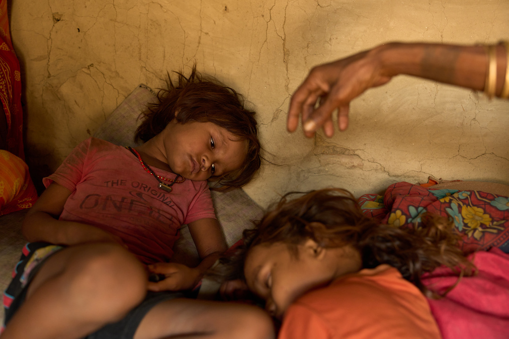 FILE - Sonam Mukhiya, left, lies next to her 3-year-old brother, Yubraj Mukhiya, and their grandmother in their home in Gaur, Nepal, on May 19, 2026. (AP Photo/Bram Janssen, File)
