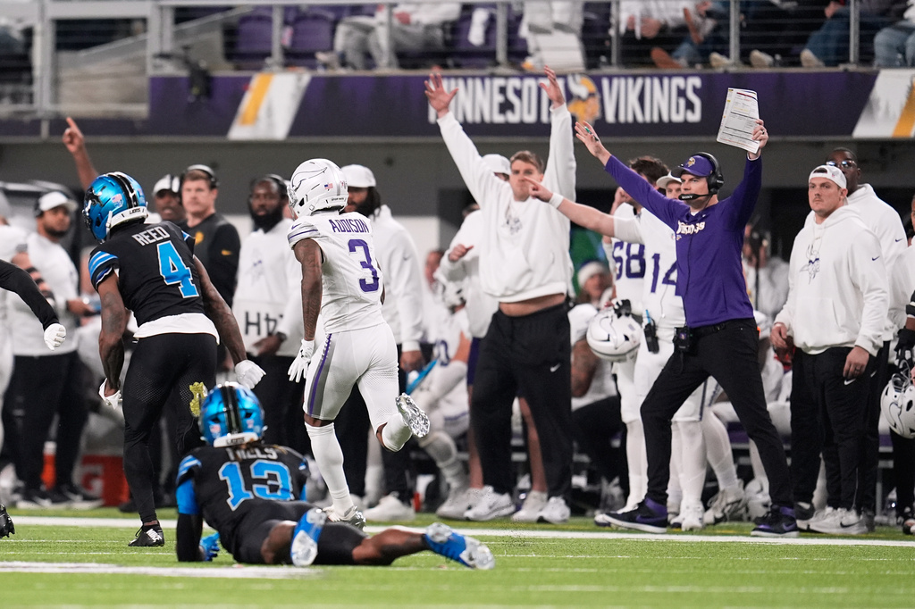 Minnesota Vikings wide receiver Jordan Addison (3) runs past Detroit Lions cornerback D.J. Reed (4), and safety Jalen Mills to score a touchdown during the second half of an NFL football game, Thursday, Dec. 25, 2025, in Minneapolis. (AP Photo/Abbie Parr)