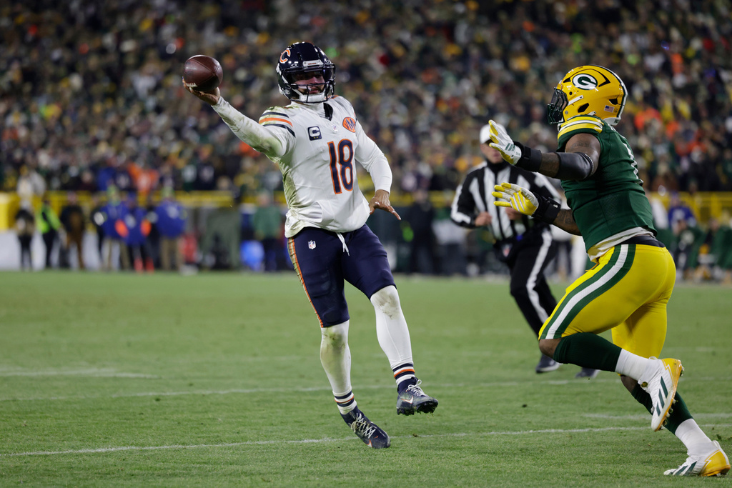Chicago Bears quarterback Caleb Williams (18) throws a pass for a touchdown against Green Bay Packers defensive end Micah Parsons, right, during the second half of an NFL football game Sunday, Dec. 7, 2025, in Green Bay, Wis. (AP Photo/Matt Ludtke)