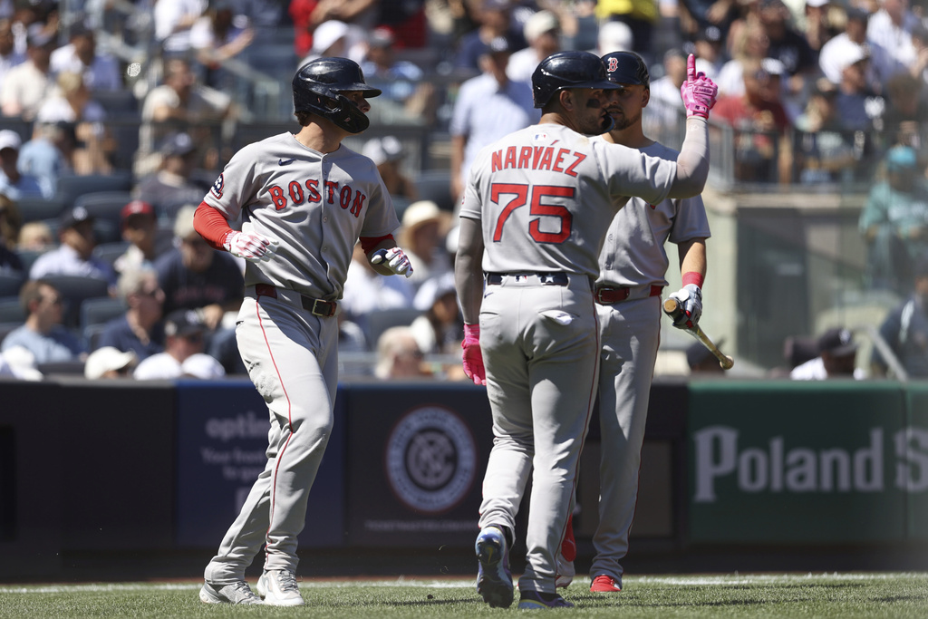 Boston Red Sox's Roman Anthony, left, and Carlos Narváez, center, react after scoring on a double hit by Trevor Story with Nathaniel Lowe, right, during the third inning of a baseball game against the New York Yankees, Saturday, Aug. 23, 2025, in New York. (AP Photo/Pamela Smith)