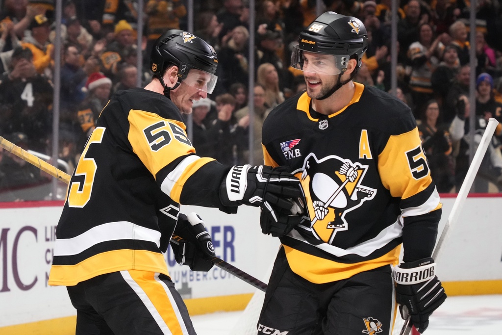 Pittsburgh Penguins' Noel Acciari (55) celebrates after his goal with teammate Kris Letang, right, during the second period of an NHL hockey game against the Montréal Canadiens in Pittsburgh, Sunday, Dec. 21, 2025. (AP Photo/Gene J. Puskar)
