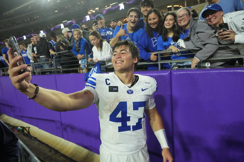 BYU quarterback Bear Bachmeier (47) takes a photo with fans in the stands after an NCAA college football game against TCU, Saturday, Oct. 3, 2026, in Fort Worth, Texas. (AP Photo/LM Otero)