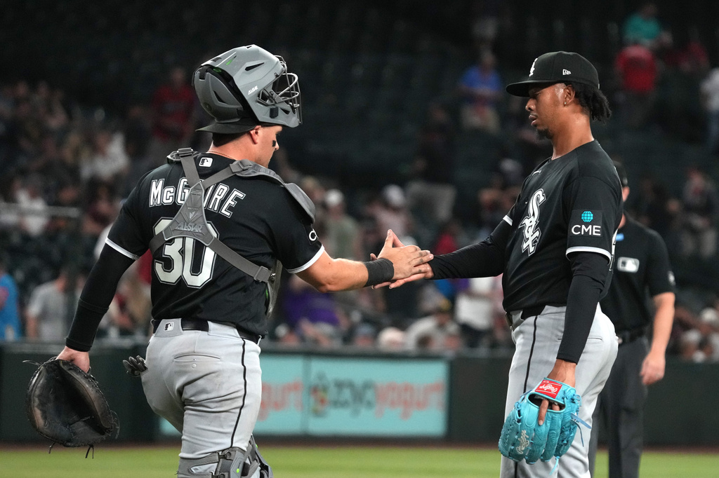 Chicago White Sox catcher Reese McGuire (30) and pitcher Osvaldo Bido celebrate after defeating the Arizona Diamondbacks in a baseball game, Tuesday, April 21, 2026, in Phoenix. (AP Photo/Rick Scuteri)