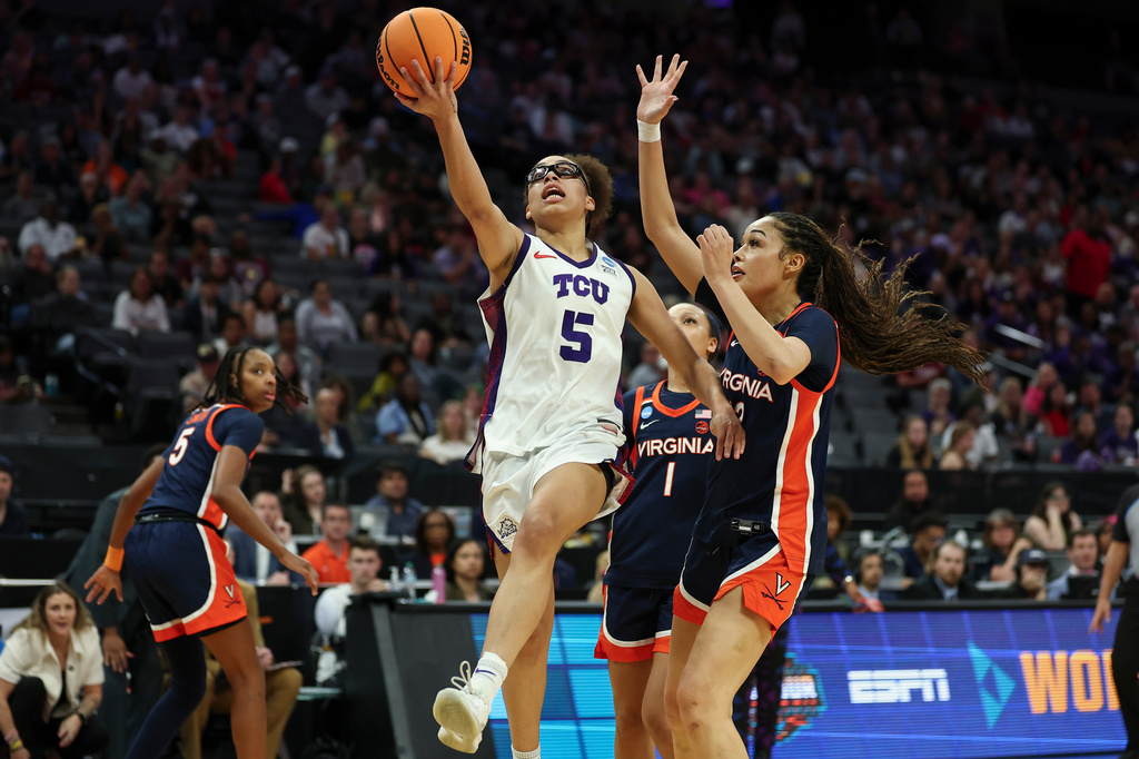 TCU guard Olivia Miles (5) goes up for a layup past Virginia forward Caitlin Weimar, right, during the first half in the Sweet 16 of the NCAA college basketball tournament Saturday, March 28, 2026, in Sacramento, Calif. (AP Photo/Sara Nevis)