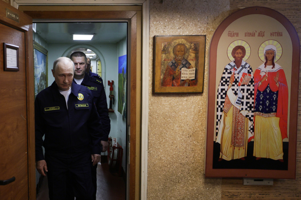 Russian President Vladimir Putin visits the Varyag missile cruiser of the Pacific Fleet to watch a military exercise near Yuzhno-Sakhalinsk, on Sakhalin Island, Russia, Wednesday, Aug. 12, 2026, as Admiral Viktor Liina follows him. (Gavriil Grigorov, Sputnik, Kremlin Pool Photo via AP)