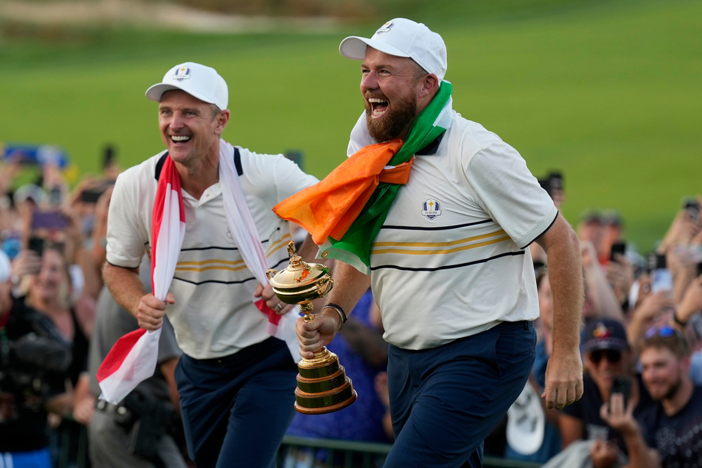 Europe's Shane Lowry and Justin Rose celebrate with the trophy after winning the Ryder Cup golf tournament against the United States on the Bethpage Black golf course, Sunday, Sept. 28, 2025, in Farmingdale, N.Y. (AP Photo/Robert Bukaty)