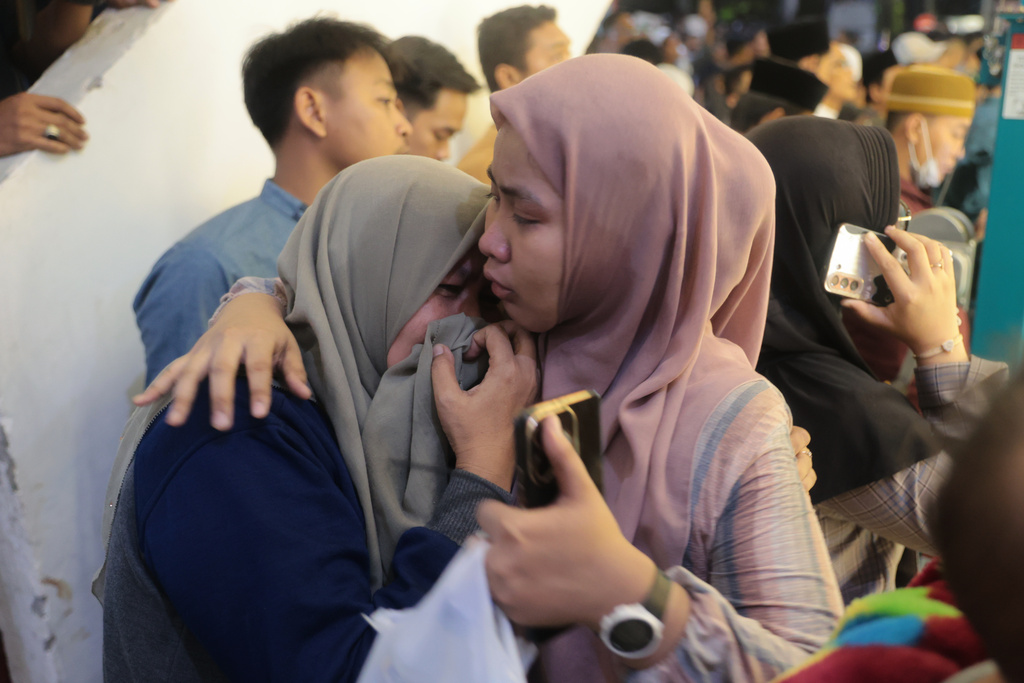 A woman is comforted as she weeps while rescue work is underway after a building collapsed at an Islamic boarding school in Sidoarjo, East Java, Indonesia, Monday, Sept. 29, 2025. (AP Photo/Trisnadi)