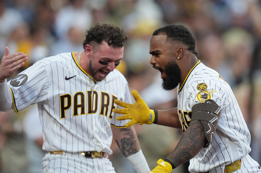 San Diego Padres' Luis Rengifo, right, celebrates with teammate Jackson Merrill after hitting a grand slam home run during the second inning of a baseball game against the Milwaukee Brewers Tuesday, Aug. 11, 2026, in San Diego. (AP Photo/Gregory Bull)