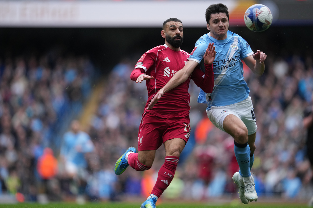 Liverpool's Mohamed Salah;, left, and Manchester City's Abdukodir Khusanov fight for the ball during the FA Cup quarter-final soccer match between Manchester City and Liverpool in Manchester, England, Saturday, April 4, 2026. (AP Photo/Jon Super)