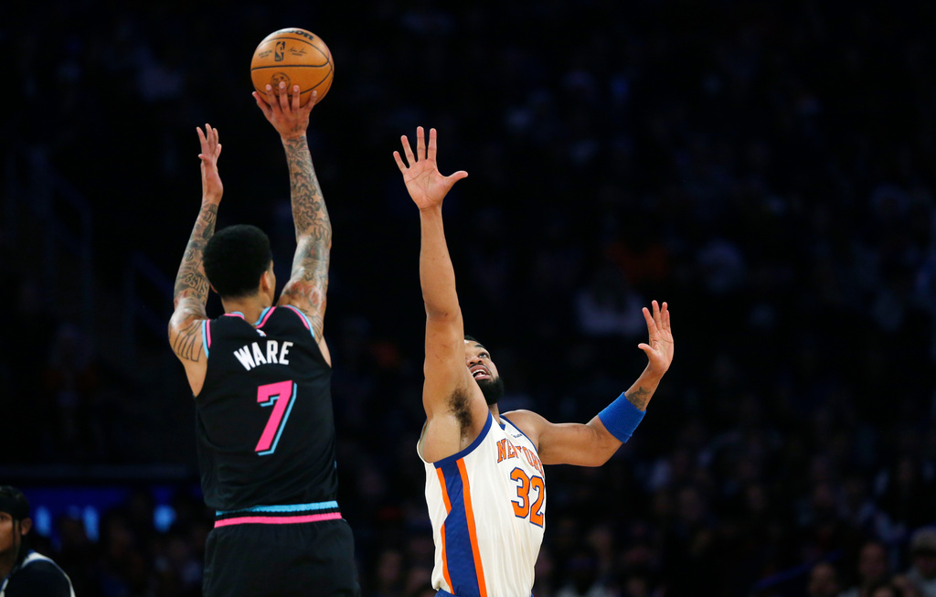 Miami Heat center Kel'el Ware (7) looks to shoot over New York Knicks center Karl-Anthony Towns (32) during the first half of an NBA basketball game Sunday, Dec. 21, 2025, in New York. (AP Photo/John Munson)