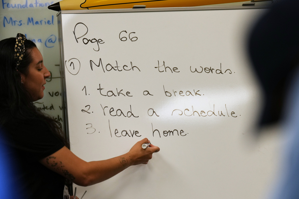 Patricia Otero writes phrases on the board as she teaches a Catholic Charities of Central Florida ESOL class to immigrants trying to learn the English language, Tuesday, Aug. 19, 2025, in Orlando, Fla. (AP Photo/Rebecca Blackwell)