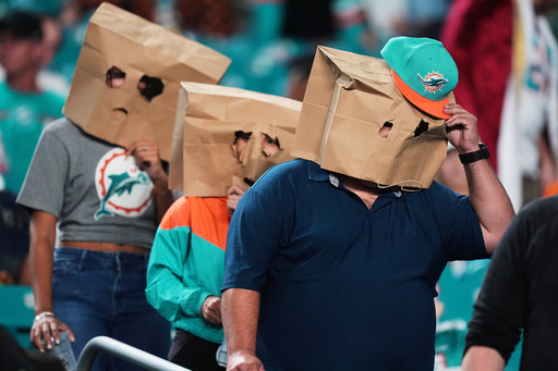 Miami Dolphins fans wear paper bags over their heads as they leave the stadium after a loss to the Baltimore Ravens in an NFL football game, Thursday, Oct. 30, 2025, in Miami Gardens, Fla. (AP Photo/Rebecca Blackwell) Miami Dolphins fans wear paper bags over their heads as they leave the stadium after a loss to the Baltimore Ravens in an NFL football game, Thursday, Oct. 30, 2025, in Miami Gardens, Fla. (AP Photo/Rebecca Blackwell)
