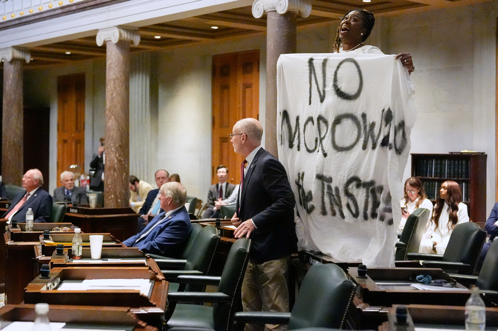 Sen. Charlane Oliver, D-Nashville, protests with a banner atop her desk in the Senate chamber during a special session of the state legislature to redraw U.S. Congressional voting maps Thursday, May 7, 2026, in Nashville, Tenn. (AP Photo/George Walker IV)