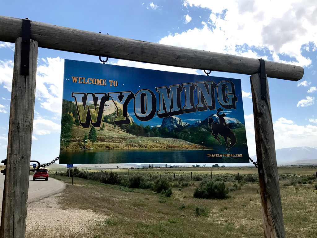 FILE - A sign on the border of Wyoming and Montana appears on the side of Belfry Highway, May 24, 2017, in Powell, Wyoming. (AP Photo/Robert Yoon, File)