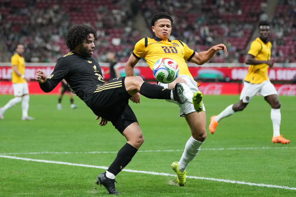 Mexico's César Huerta, left, and Ecuador's Patrik Mercado compete for the ball during a friendly soccer match at Akron stadium in Guadalajara, Mexico, Tuesday, Oct. 14, 2025. (AP Photo/Eduardo Verdugo)