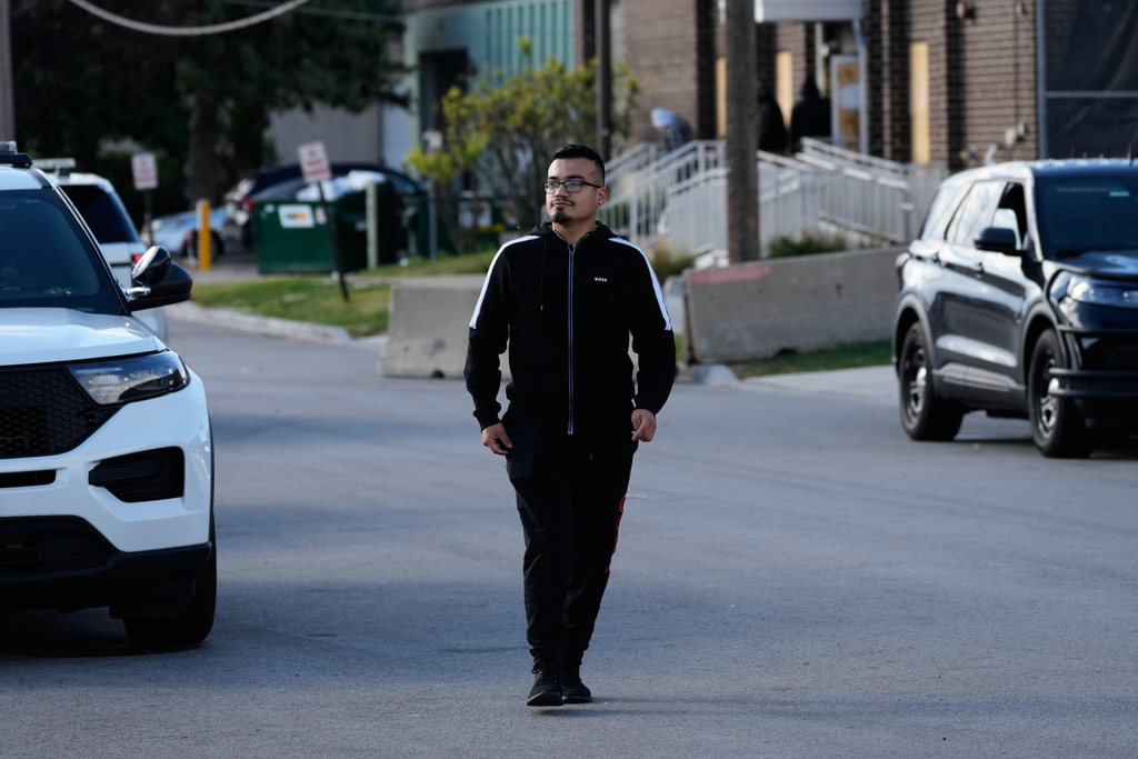 Delfino Ropez walks along the street after handing prescription medication over to a security guard for his uncle who was detained outside an ICE processing facility in the Chicago suburb of Broadview, Ill., Tuesday, Oct. 21, 2025. (AP Photo/Nam Y. Huh)