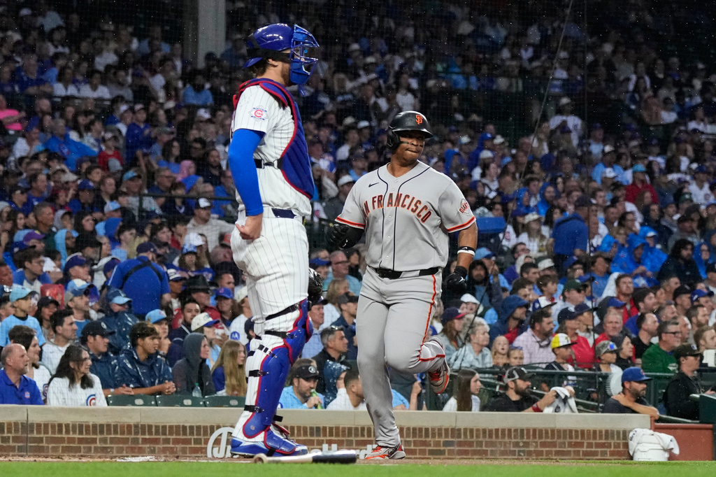 San Francisco Giants' Rafael Devers, right, scores on a one-run single by Jung Hoo Lee, of South Korea, as Chicago Cubs catcher Carson Kelly looks to the field during the first inning of a baseball game in Chicago, Sunday, June 7, 2026. (AP Photo/Nam Y. Huh)