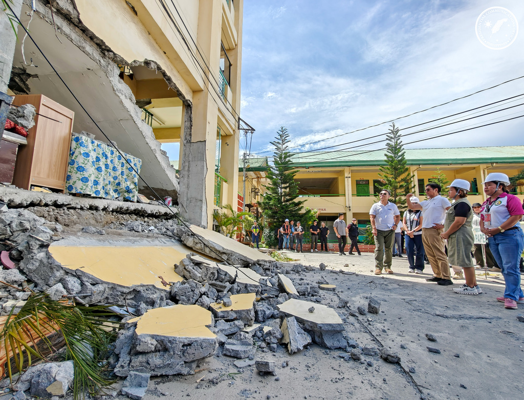 In this handout photo provided by the Presidential Communications Office, Philippine President Ferdinand Marcos Jr., third from right, talks during his visit at an earthquake damaged school in General Santos city, Philippines, Wednesday, June 10, 2026. (Presidential Communications Office via AP)
