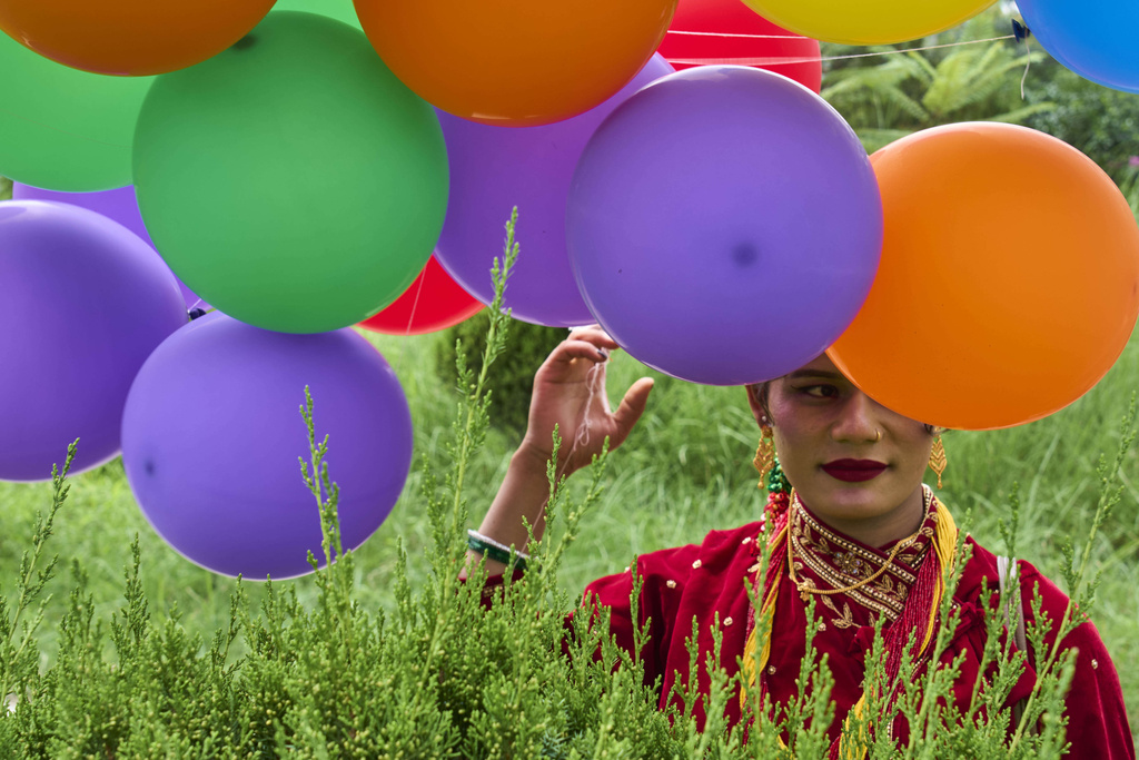 A participant holds balloons during the Pride Parade in Kathmandu, Nepal, Sunday, Aug. 10, 2025. (AP Photo/Niranjan Shrestha)