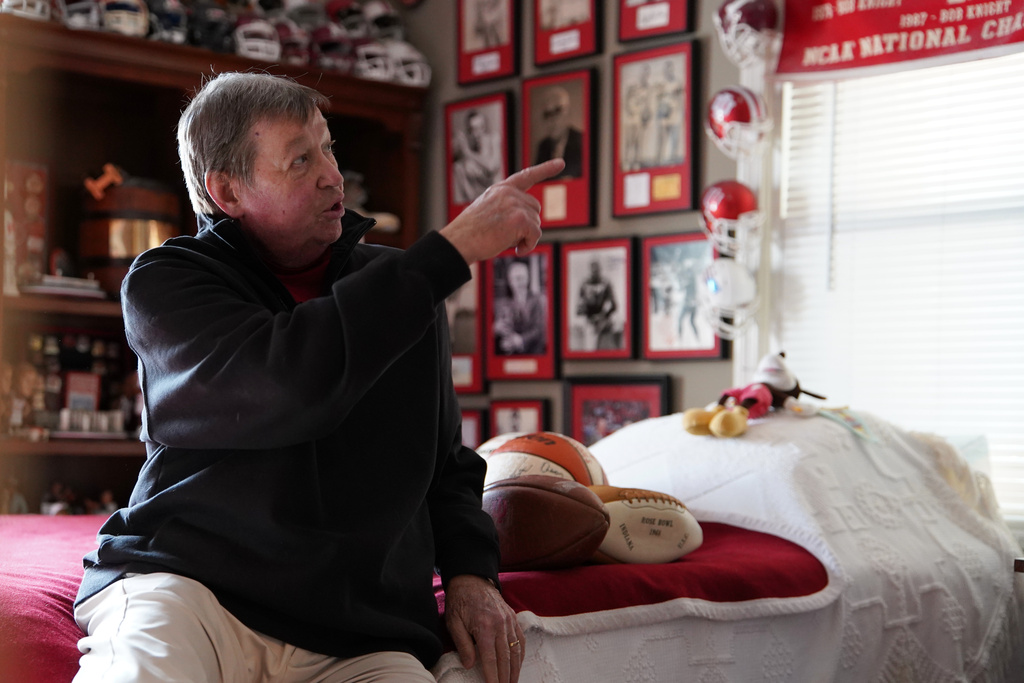 Bill Murphy points to a wall of framed sports photos in a room at his home in Greenfield, Ind., Wednesday, Dec. 17, 2025. (AP Photo/Obed Lamy)