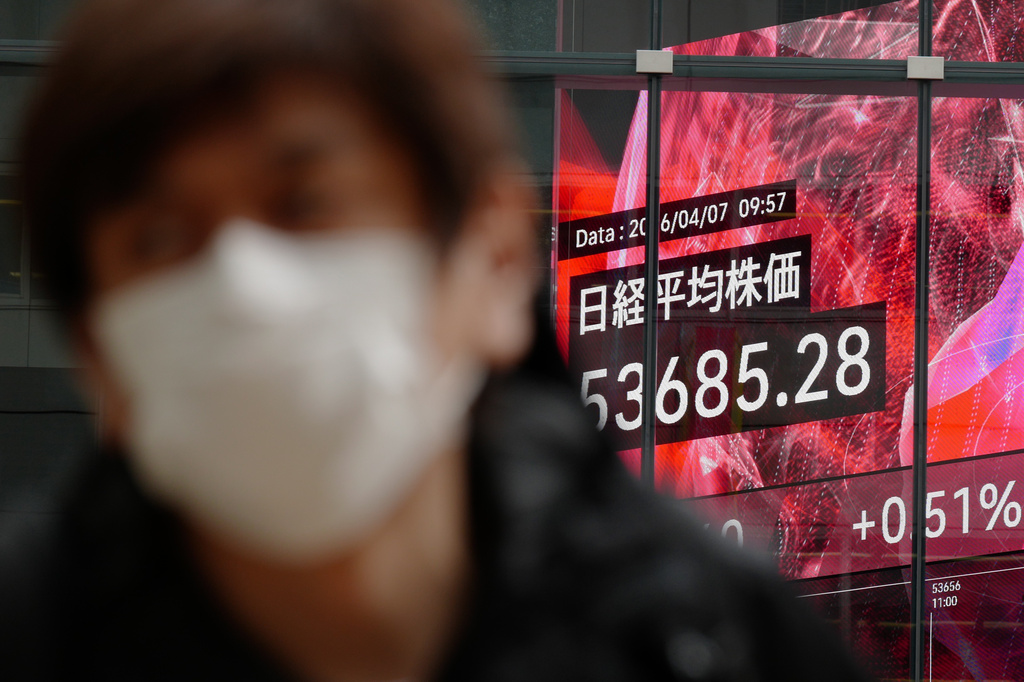 A person walks in front of an electronic stock board showing Japan's Nikkei index at a securities firm Tuesday, April 7, 2026, in Tokyo. (AP Photo/Eugene Hoshiko)