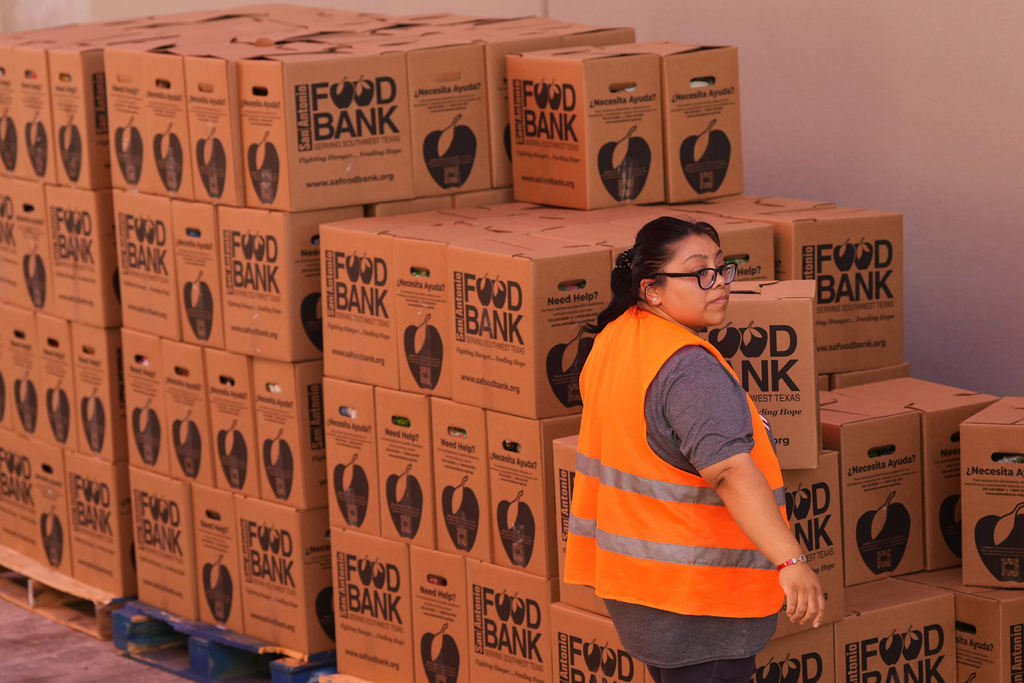 Volunteer Cindy Leiva helps load a vehicle during a food distribution targeting federal employee households affected by the federal shutdown as well as SNAP recipients, Monday, Oct. 27, 2025, in San Antonio. (AP Photo/Eric Gay)