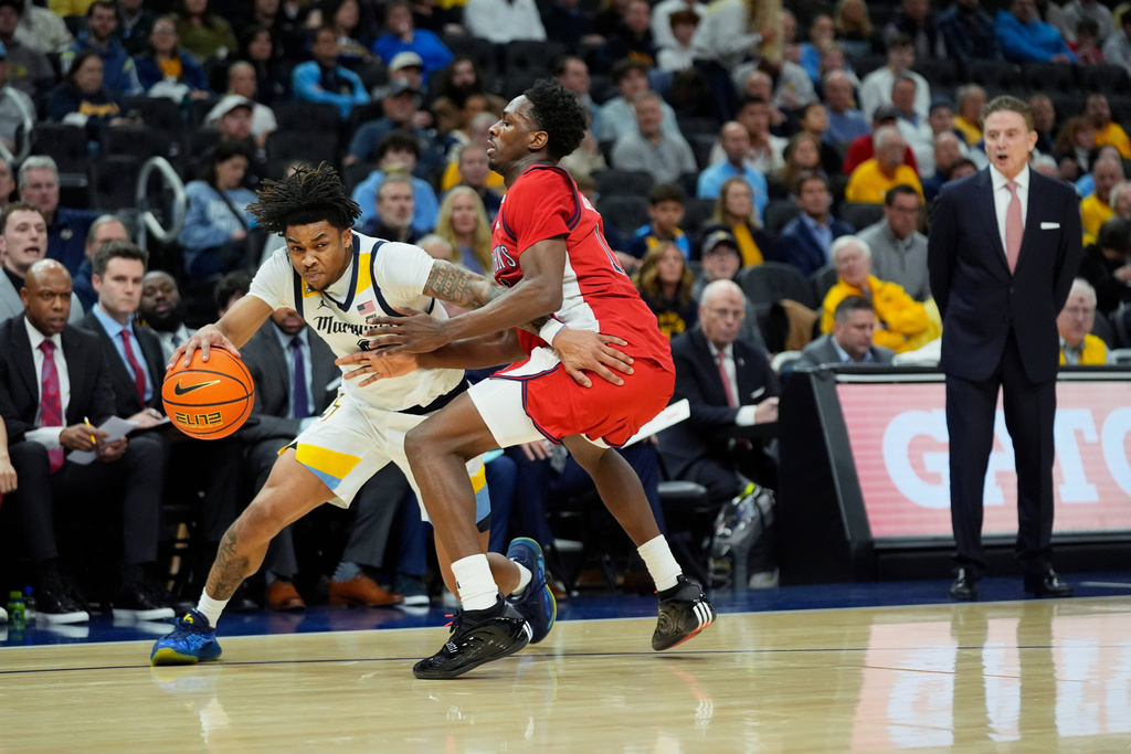 Marquette's Nigel James Jr., left, drives to the basket against St. John's' Ian Jackson during the first half of an NCAA college basketball game Wednesday, Feb. 18, 2026, in Milwaukee. (AP Photo/Aaron Gash)