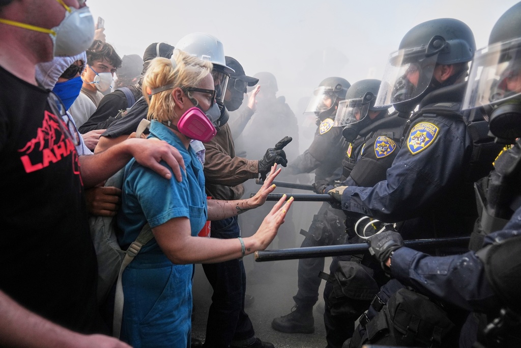 FILE - Protesters against President Donald Trump's immigration crackdown confront police on the 101 Freeway near the Metropolitan Detention Center in downtown Los Angeles, June 8, 2025. (AP Photo/Jae C. Hong, File)
