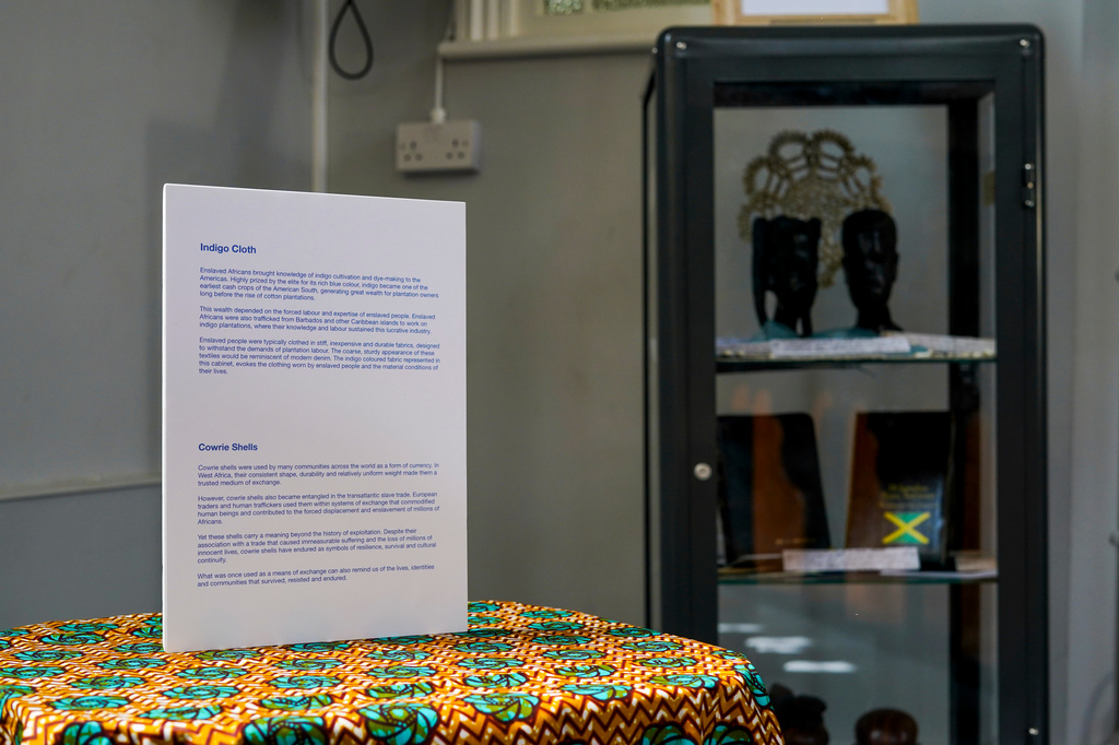 A display featuring information about indigo cloth and cowrie shells is seen at a small exhibition inside a church, in London, Sunday, Sept. 6, 2026. (AP Photo/Alberto Pezzali)