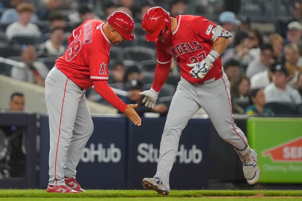 Los Angeles Angels' Mike Trout, right, celebrates with Angels third base coach Keith Johnson, left, after hitting a three-run home run during the sixth inning of a baseball game against the New York Yankees, Monday, April 13, 2026, in New York. (AP Photo/Yuki Iwamura)