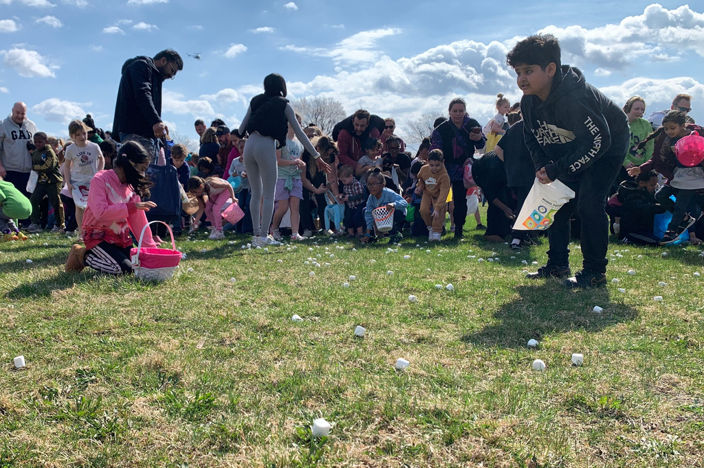 Children and their parents collect marshmallows dropped from a helicopter during the annual Marshmallow Drop event held at Nankin Mills Park in Westland, Mich., on Friday, April 3, 2026. (AP Photo/Mike Householder)