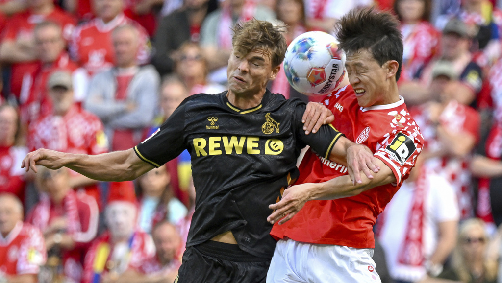 Mainz's Jae-sung Lee, right, plays against Cologne's Joel Schmied during the German Bundesliga soccer match between Mainz and Cologne at the Mewa Arena in Mainz, Germany, Sunday, Aug. 24, 2025. (Torsten Silz/dpa via AP)