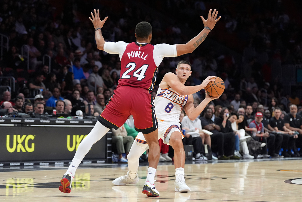 Phoenix Suns guard Grayson Allen (8) looks to pass past Miami Heat guard Norman Powell (24) during the first half of an NBA basketball game, Tuesday, Jan. 13, 2026, in Miami. (AP Photo/Rebecca Blackwell)