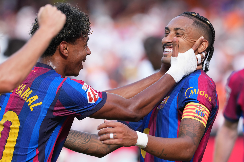 Barcelona's Raphinha, right, celebrates with teammate Lamine Yamal after scoring his side's third goal during the Spanish La Liga soccer match between Valencia and Barcelona in Valencia, Spain, Sunday, Sept. 6, 2026. (AP Photo/Alberto Saiz)
