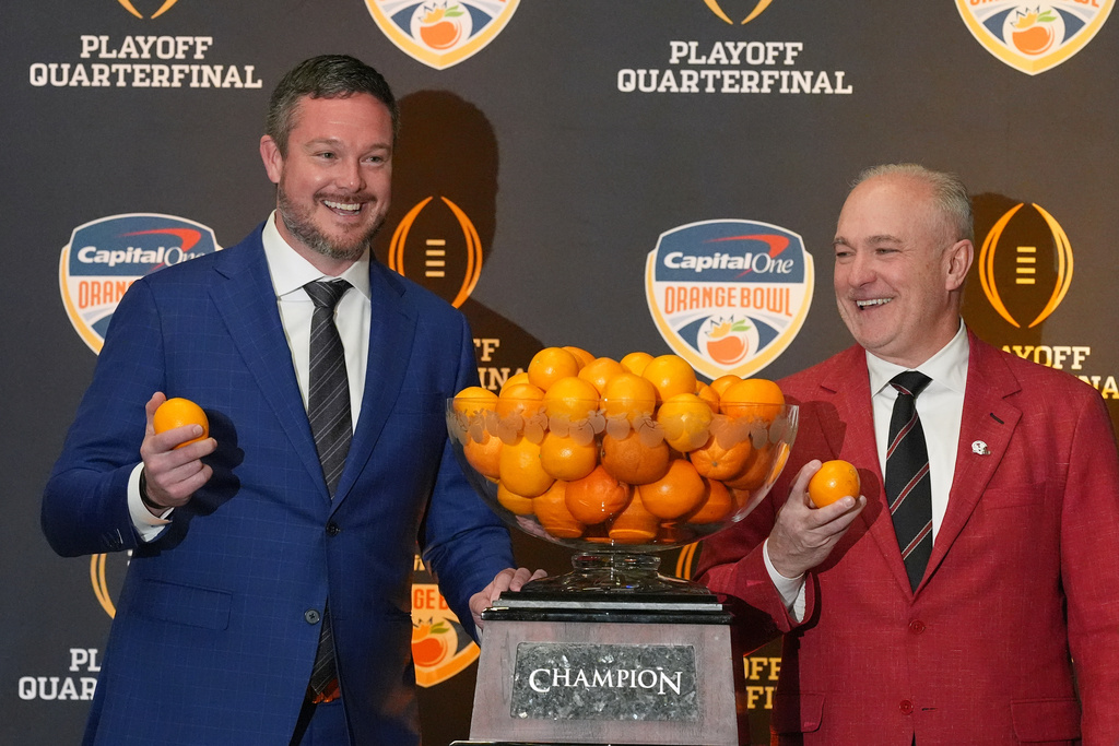 Oregon head coach Dan Lanning, left, and Texas Tech head coach Joey McGuire pose with the Orange Bowl trophy at a press conference ahead of the Orange Bowl College Football Playoff quarterfinal game, Wednesday, Dec. 31, 2025, in Dania Beach, Fla. (AP Photo/Rebecca Blackwell)